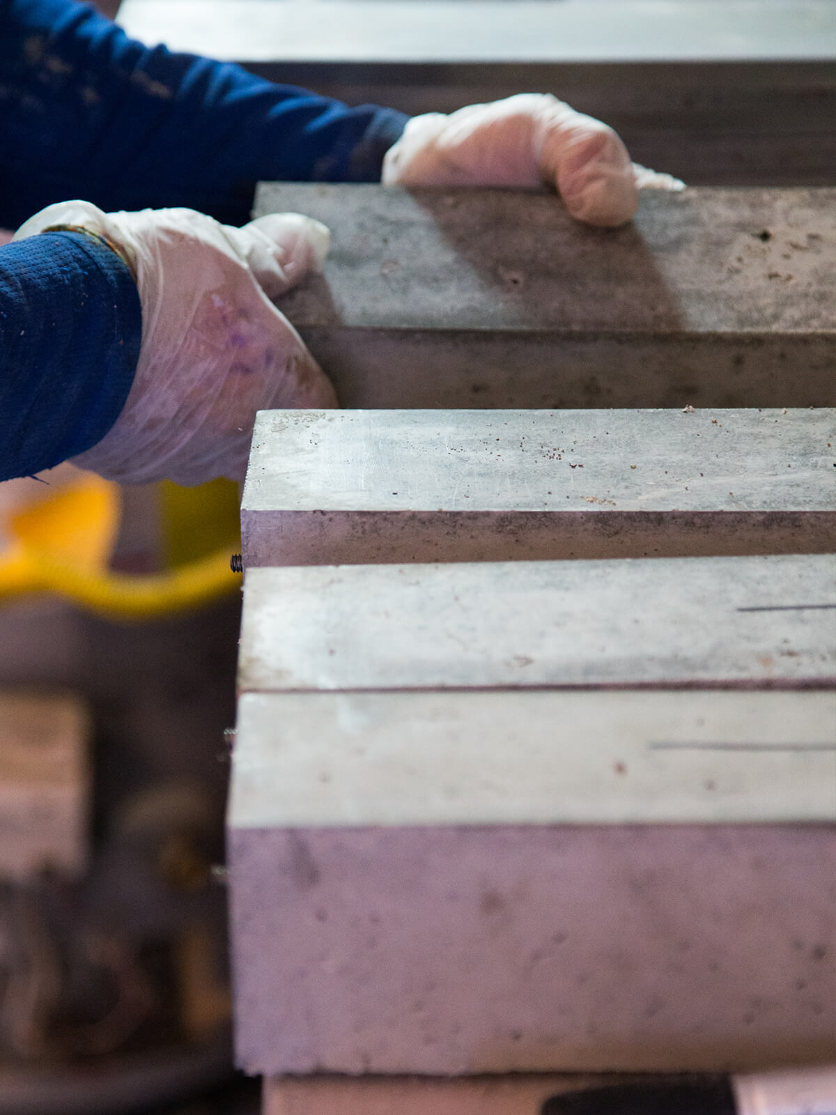 man placing slabs of concrete on top of each other